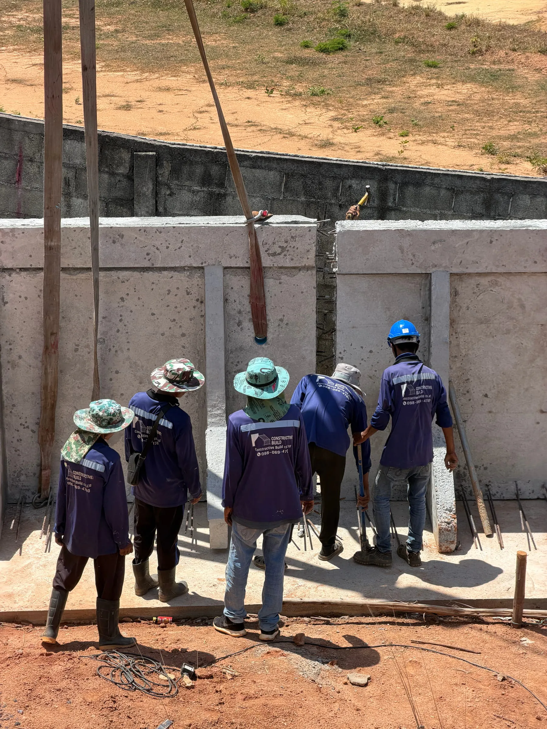 Five C:B crew members at a precast retaining wall structure