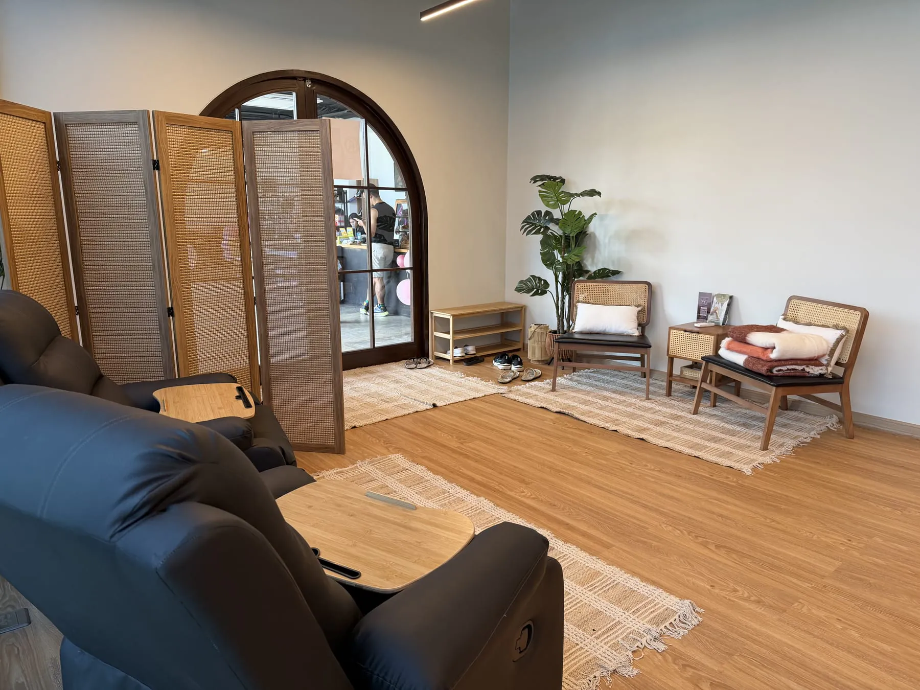 Live More Clinic: recovery lounge with arched glass doorway and rattan screen